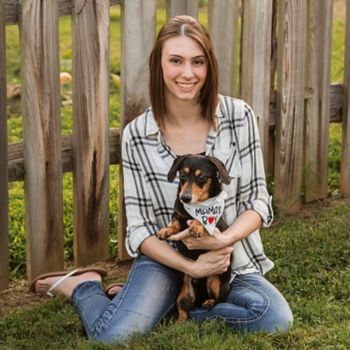 vet staff sitting on lawn with a dog
